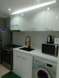 a kitchen with a sink and a washing machine at Breathtaking Studio Apartment in Marjan Island in Ras al Khaimah