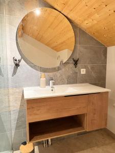 Chalet rénové, charme montagnard et confort moderne في لو ديفولي: حمام مزود بحوض ومِرآة