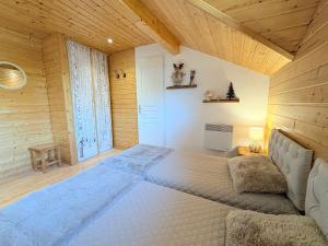 Chalet rénové, charme montagnard et confort moderne في لو ديفولي: سرير كبير في غرفة بجدران خشبية