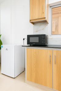 un forno a microonde seduto sopra un bancone accanto a un frigorifero di Moonlight 1 Bed Apartment a Dargai