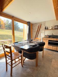 Chalet rénové, charme montagnard et confort moderne في لو ديفولي: غرفة طعام مع طاولة وكراسي ومطبخ +17 صورة