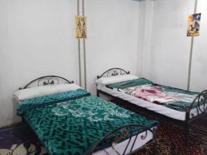 two beds sitting next to each other in a room at Sun Rise House Luxor in Al Aqālitah