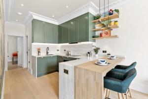 a kitchen with green cabinets and a wooden island at 1 Bed Flat in London in London +12 photos