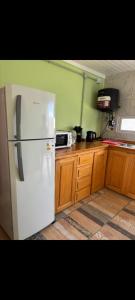 a kitchen with a white refrigerator and wooden cabinets at Hospedaje la querencia in San Antonio de Areco