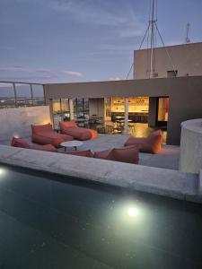 een huis met een zwembad met banken en tafels bij STÚDIO - Novo e Sofisticado! in Princesa dʼOeste