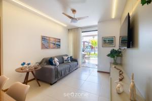una sala de estar con un sofá y una mesa en Condominio con Piscina a 450m de la Playa en Itacimirim - VBRs, en Pojuquinhos
