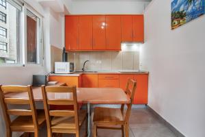 eine Küche mit orangefarbenen Schränken sowie einem Tisch und Stühlen in der Unterkunft Apartamento Práctico en Santa Cruz in Santa Cruz de Tenerife