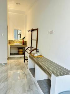 a bench in a room with a mirror and a sink at The Opulent Retreat in Ahangama