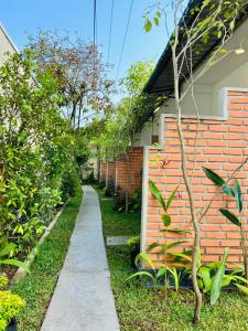 a garden with a sidewalk next to a brick wall at The Opulent Retreat in Ahangama