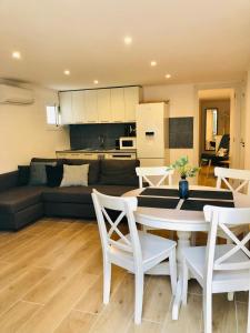 a living room with a couch and a table and chairs at 101 - Beachside Renovated 1BR apt w private garden in Cambrils