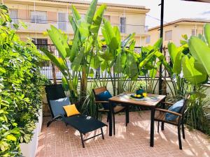 a patio with a table and chairs and plants at 101 - Beachside Renovated 1BR apt w private garden in Cambrils