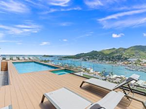 a balcony with a pool and a view of a harbor at The Hills Residence at Simpson Bay in Simpson Bay