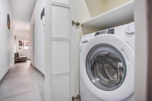 eine Waschmaschine in einem weißen Waschraum mit Flur in der Unterkunft Apartamento Práctico en Santa Cruz in Santa Cruz de Tenerife