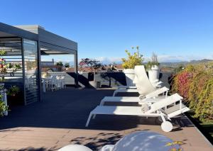 a row of white lounge chairs on a patio at Langhe Panorama in Alba
