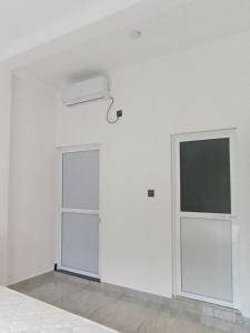 una camera bianca con due porte e una finestra di Blue Heaven Villa ad Ahangama