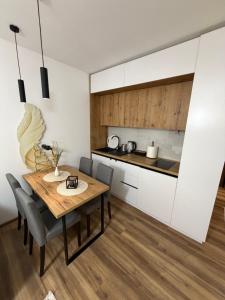 a kitchen and dining room with a wooden table and chairs at Gold Elegant & Spa Kop in Kopaonik