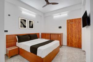 a bedroom with a bed and a flat screen tv at Collection O Kanifnath Trek Pune in Jadhavwadi
