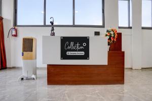 a counter in a room with a sign and flowers at Collection O Kanifnath Trek Pune in Jadhavwadi