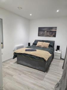 una camera da letto con un letto grande in una stanza bianca di Noahs Corner a Milford Haven