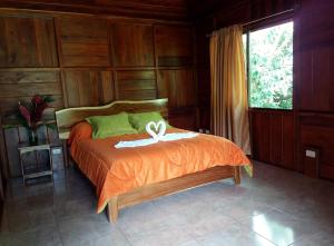 a bedroom with a bed with a white bow on it at Rancho de Lelo Ecolodge in Monteverde Costa Rica