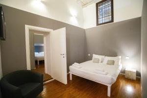 a bedroom with a white bed and a black chair at Spacious Loft in Rome Jewish Ghetto in Rome