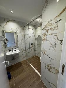 a bathroom with a sink and a glass shower at Blue Studios by Comfort Suites in Golem