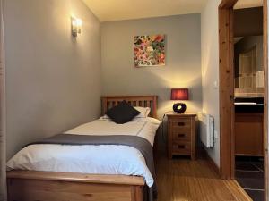 a small bedroom with a bed and a night stand at Orchard Cottage in Willingham