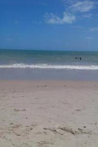 einen Strand mit Menschen im Wasser und im Meer in der Unterkunft Casa de praia in Pitimbu