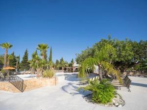 a resort with palm trees and a swimming pool at Camping L'Orangeraie in Cálig