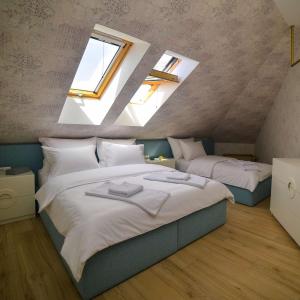 a bedroom with two beds and two skylights at Tomy Forest Cigar Bar in Ocka Gora