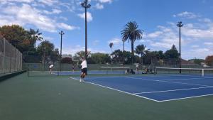 a group of people playing tennis on a tennis court at Linkside lodge in Gqeberha