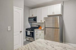 a kitchen with a stainless steel refrigerator and a stove at Beautiful Brand New Tower Grove Unit 1s in Clifton Heights