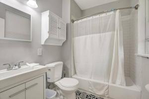 a white bathroom with a toilet and a sink at Beautiful Brand New Tower Grove Unit 1s in Clifton Heights +4 photos