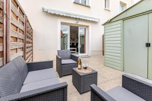 a patio with wicker furniture and a table and chairs at La Maison Mazarin in Chilly-Mazarin