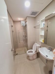 a bathroom with a toilet and a shower and a sink at Apartment Podomoro Lincoln Delipark in Medan