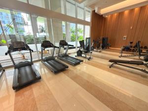 a gym with a bunch of treadmills in a room at Apartment Podomoro Lincoln Delipark in Medan