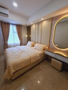 a bedroom with a large bed and a window at Apartment Podomoro Lincoln Delipark in Medan