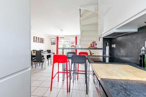 a kitchen with red chairs and a counter in a room at La Maison Mazarin in Chilly-Mazarin