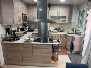 una cocina con fregadero y estufa horno superior en Holiday comarruga, en La Playa