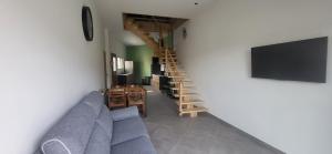a living room with a blue couch and a staircase at la petite écurie in Soleymieu