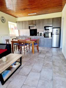 ein Wohnzimmer mit Tisch und Küche in der Unterkunft La Colline d'Estaing, Maison 4 pers avec terrasse in Le Nayrac