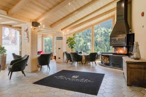 een woonkamer met een open haard en een tafel en stoelen bij Hotel Miravalle in Valdidentro