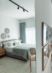 a white bedroom with a bed and a window at Grace Living Studio 201 in Limassol