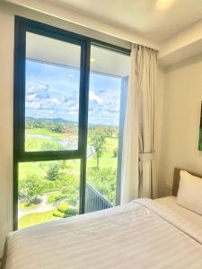 a bedroom with a bed and a large window at Bangtao Rooftop Seaview Laguna Skypark Condominium in Bang Tao Beach