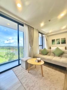 a living room with a couch and a table at Bangtao Rooftop Seaview Laguna Skypark Condominium in Bang Tao Beach