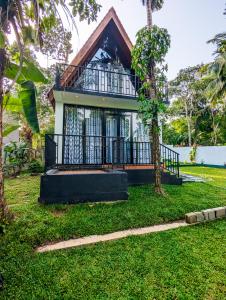 a house with a balcony in a yard at Shenu Villa in Talpe +16 photos