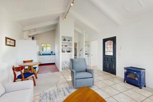 een woonkamer met een open haard en een tafel en stoelen bij Perched on the Bluff - Casita in Mendocino