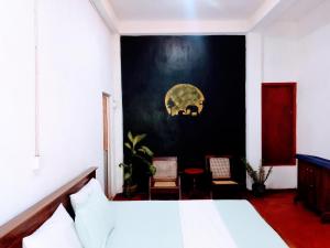 a bedroom with a bed and a black wall at Ancient Gardens Villa in Pinnawala +28 photos