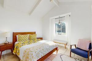 een slaapkamer met een bed, een stoel en een raam bij Perched on the Bluff - Casita in Mendocino