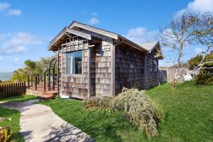 een tiny house met een speeltuin in een yard bij Perched on the Bluff - Casita in Mendocino